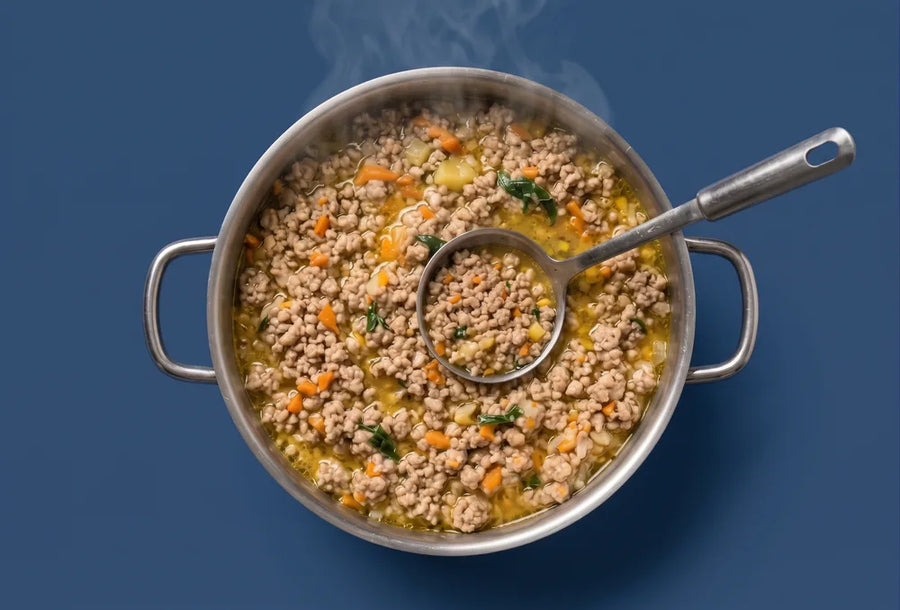 A steel pot of freshly cooked chicken and vegetables